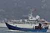 Ein fiskebåt seglar forbi eit kinesisk krigsskip under militærøvinga utanfor Taiwan 11. april.