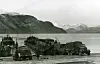 Olderdalen i Kåfjord i Nord-Troms i november 1944: To tyske landgangsprammar tek om bord lastebilar og hengarar på ferjeleiet for transport til Lyngseidet. Nærast ein Opel Blitz. I bakgrunnen Lyngsalpane.
