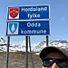 Endeleg kan eg sjå det blå skiltet eg har drøymt om i tolv døgn: Hordaland fylke – Odda kommune.