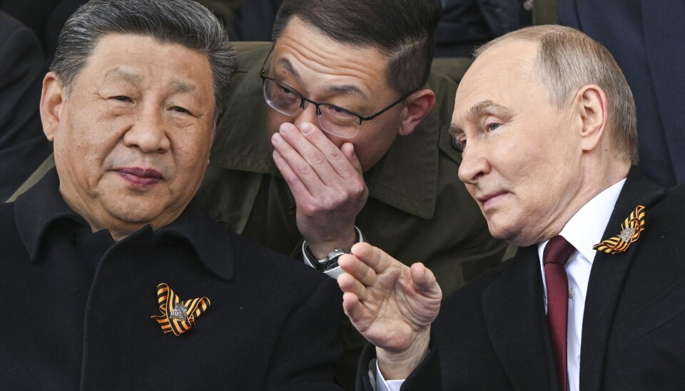 Russlands president Vladimir Putin (t.h) og Kinas president Xi Jinping, pratar medan dei ser på militærparaden på sigersdagen i Moskva, fredag 9. mai 2025. Russian President Vladimir Putin, right, and Chinese President Xi Jinping, left, talk as they watch the Victory Day military parade in Moscow, Russia, Friday, May 9, 2025, during celebrations of the 80th anniversary of the Soviet Union's victory over Nazi Germany during the World War II. (Sergei Bobylev/Photo host agency RIA Novosti via AP)