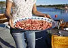 Kvinne i dongeribukse serverer reker på fat. Brygge.Shrimps served in SørlandetFoto: Berit Roald / NTBNB! MODELLKLARERT