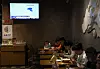 People dine near a television screen showing a news report on China's 'Justice Mission 2025' military drills around Taiwan, at a restaurant in Beijing, China December 30, 2025. REUTERS/Tingshu Wang
