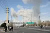 People gather on the sides of a road as smoke rises in the background following an explosion, amid the U.S.-Israeli conflict with Iran, in Tehran, Iran, March 5, 2026. Majid Asgaripour/WANA (West Asia News Agency) via REUTERS ATTENTION EDITORS - THIS PICTURE WAS PROVIDED BY A THIRD PARTY